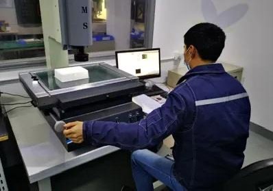 Operator inspecting machined parts with measuring equipment